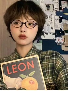 Close-up of vintage Y2K tortoiseshell oval frame glasses worn by a female model