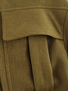 Close-up of olive green bomber jacket pocket with detailed twill fabric and stitching