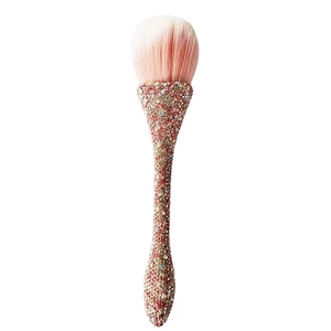 Detail of soft pink gradient bristles and champagne rhinestone handle on a large powder brush