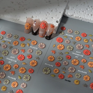 Detailed macro view of 3D embossed Halloween pumpkin and maple leaf nail art decals