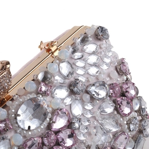 Dettaglio macro della borsa da sera con strass rosa e chiusura floreale dorata