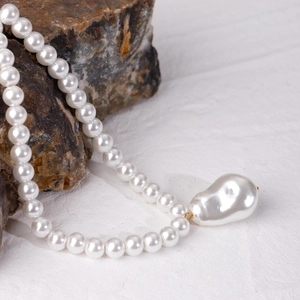 Collana con pendente in perla barocca e chiusura dorata su base in acciaio inossidabile