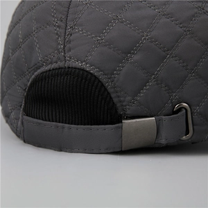 Close-up of winter cap with dark grey quilted pattern and metal adjustable buckle