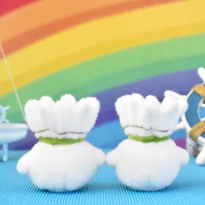 Close-up of white badminton shuttlecock plush keychains with green decorative neck bands