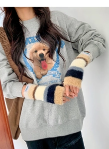 Détail de manchons en fausse fourrure pelucheuse avec motif à rayures sur un sweat gris