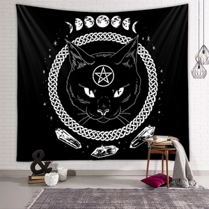Detail of occult black cat tapestry with moon phases on a white brick wall background