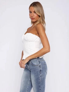 White Y2K tube top with ruched details and ruffle hem paired with denim jeans