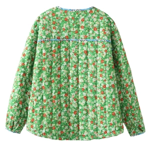 Detail view of green floral quilted jacket showing vertical stitching and vintage pattern