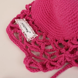 Handmade hollow crochet sun hat for women in vibrant rose pink with floral lace tag