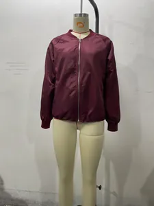 Close-up of glossy wine red bomber jacket with metal zipper and ribbed cuffs