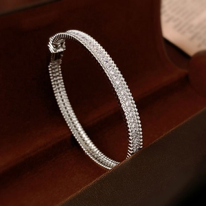 Detailed close-up of a silver buckle bangle with triple-row inlaid white zircons