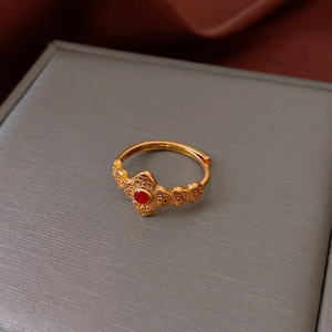 Détail macro de la bague plaquée or avec rubis rouge et gravure évidée vintage