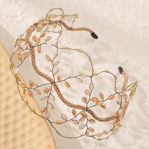Detailed close-up of handmade bridal headband with amber beads and gold wire weaving