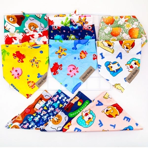 Close-up of cotton pet bandanas with cartoon prints and Hand Made leather labels