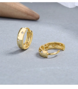 Macro shot of 925 silver star earrings with gold plating and fine zircon crystals
