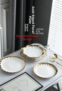 Detail of white floral ceramic plate with gold rim and wavy petal edges for dining