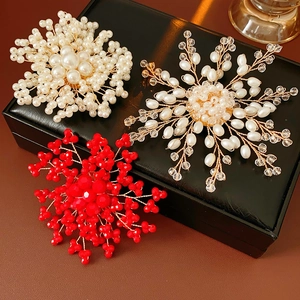 Close-up of handmade pearl flower brooches with metal wire on black jewelry box