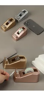Nahaufnahme von drei luxuriösen Klebebandspendern in Roségold und Silber auf einem Ständer