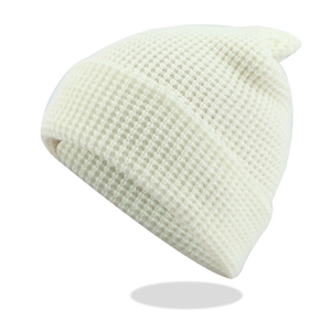 Detail der cremefarbenen Waffelstrickstruktur und des dicken Umschlags der Mütze