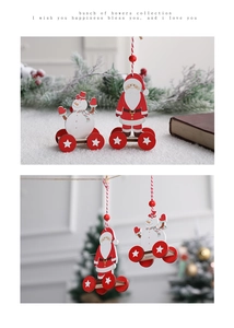 Detail of wooden Santa and Snowman cart ornaments on a festive pine and berry background