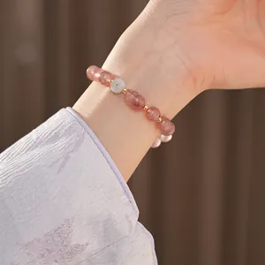 Elegant strawberry quartz and agate beaded bracelet with gold accents on a woman's wrist