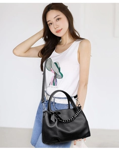 Close-up of black lychee grain leather tote bag featuring a decorative thick chain strap
