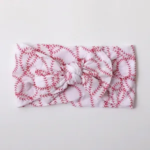Detail showing soft nylon baby headband with red baseball stitch pattern and bow knot