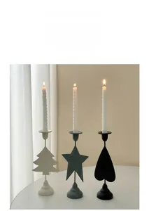 Close-up of Nordic style metal candle holders in heart and star shapes with lit candles