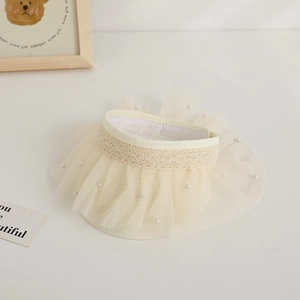 Detail of baby sun hat featuring cream lace trim and mesh layers with pearl accents