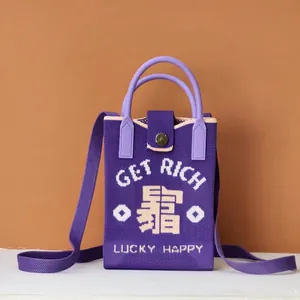 Detail of purple knitted crossbody bag featuring Get Rich embroidery and metal clasp