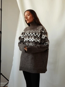 Close-up of thick geometric Fair Isle knit texture on oversized high-neck sweater