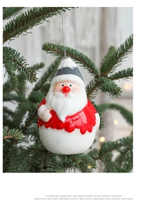 Gros plan d'une figurine de Père Noël sur un sapin de Noël avec un éclairage bokeh chaleureux
