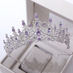 Detailed shot of luxurious silver bridal tiara with purple crystals in a white jewelry box