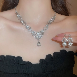 Detail of silver leaf and floral necklace with sparkling drop-shaped crystal pendant