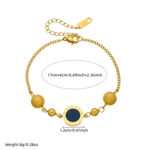 Gold chain bracelet featuring a Roman numeral coin and spheres on a white background