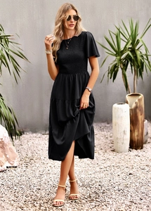 Detailed view of women's black tiered midi dress with smocked bodice and layered skirt