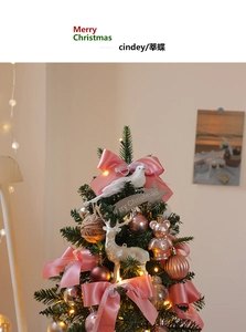 Mini DIY Christmas tree detail with pink bows, reindeer, and warm LED lights
