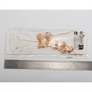 Detailed view of golden ginkgo leaf pendants with brushed texture and adjustable fine chain
