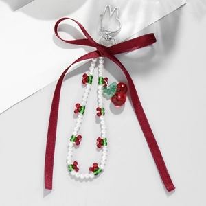 Fashionable cherry pendant keychain featuring a red ribbon bow and white pearl beads