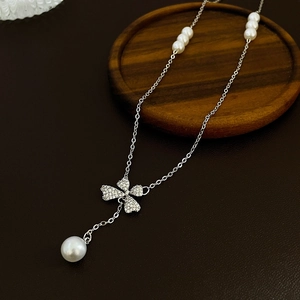 Nahaufnahme der Silber-Kleeblatt-Kette mit Zirkonia und hängenden weißen Perlen