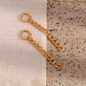 Vue détaillée des boucles d'oreilles chaîne Figaro dorées sur support en pierre