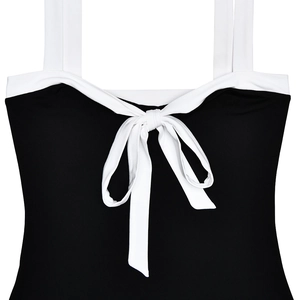 Close-up of black bodycon dress featuring white straps and a decorative bow detail