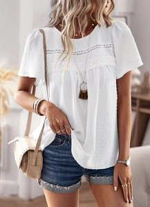 Detail of white round neck top featuring Swiss dot texture and lace puff sleeves