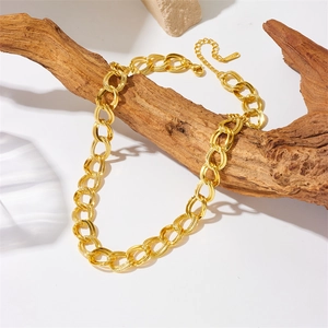 Textured gold-plated stainless steel chain necklace displayed on a natural wood branch