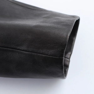 Close-up of the cuff details on a black PU leather jacket showing neat stitching and texture