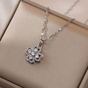 Macro shot of silver clover pendant necklace with sparkling cubic zirconia on jewelry box