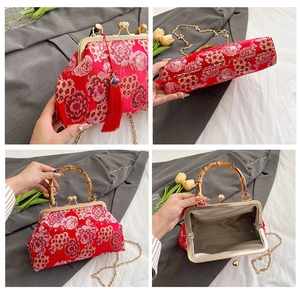 Detail view of red floral embroidery bag with bamboo handle and golden chain