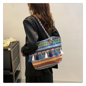 Close-up of bohemian woven tote bag with colorful geometric patterns and decorative tassels