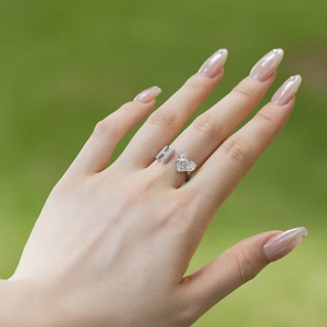 Close-up of S925 sterling silver ring with zircon heart and letter H on a model's finger