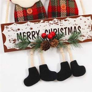 Detailed close-up of Merry Christmas door hanger with fabric plaid dolls and pine cones